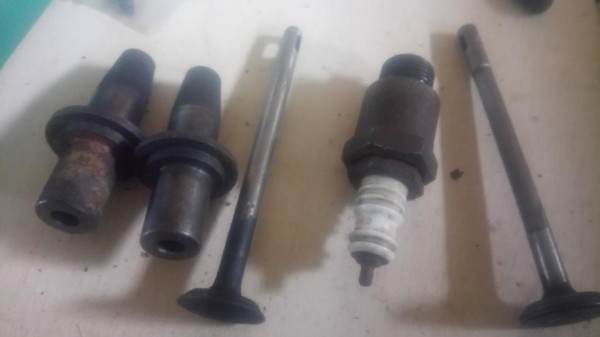 Die alten Ventilführungen und die alte Zündkerze und die zwei Ventile